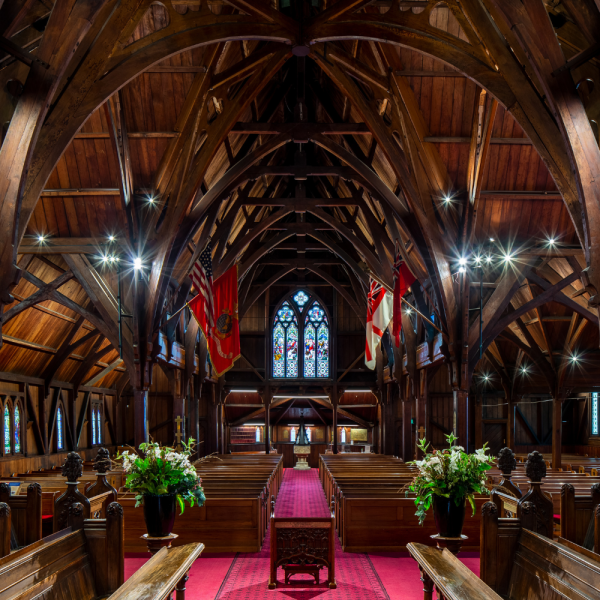 Old St Paul's interior image with a panorama view toward baptistry including flags, main aisle and pews.