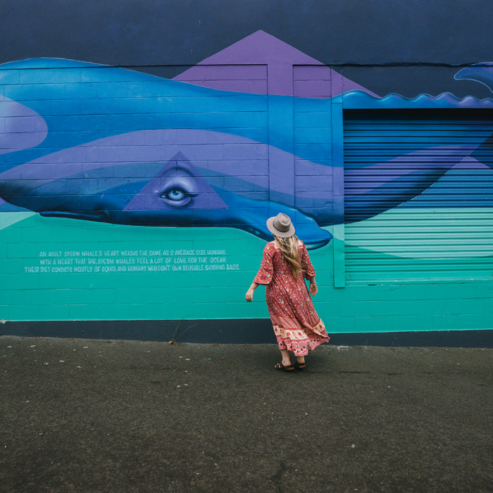 Street Art of a whale by Kelly Spencer with woman walking in front