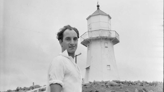 Historic black and white photo of Pencarrow Lighthouse keeper Mr R G Jones, in front of the lighthouse in 1958