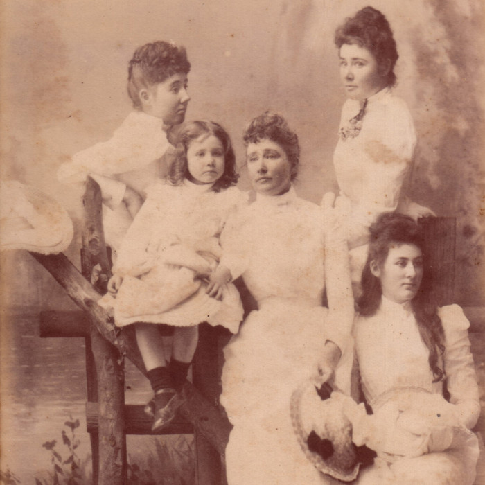 A thoughtful Sophia Kerr Taylor sits at a table surrounded by her children.